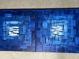 un tableau accroché au mur d'une pièce, sur fond bleu