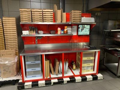 une cuisine rouge et blanche avec plein de boîtes sur le plan de travail