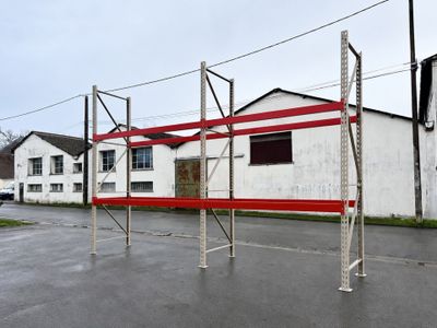 une clôture rouge et blanche devant un bâtiment blanc