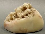 a white stone sculpture with a dragon on top of it