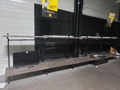deux ordinateurs portables posés sur un banc dans un entrepôt