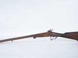 un vieux fusil avec un canon en bois et une poignée en bois