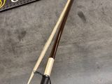 a pool cue and a billiards rack on a table