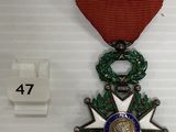 une photo d'une médaille accompagnée d'un ruban rouge posée sur une table