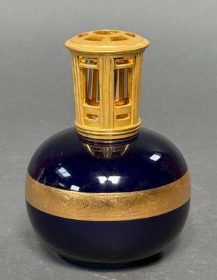a blue and gold vase with a cage on top