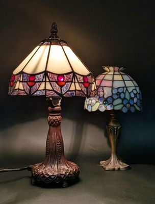 two lamps sitting on a table next to each other on a wall
