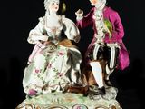a figurine of a man and a woman sitting on a bench