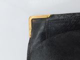 the back of a black purse with a wooden handle