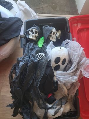 deux squelettes dans une valise posée par terre, à côté d'une boîte rouge