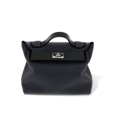 le petit sac noir est posé sur une surface blanche