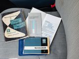 a cell phone sitting on top of a seat next to a book