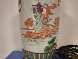 a vase with a painting on it sitting on a table