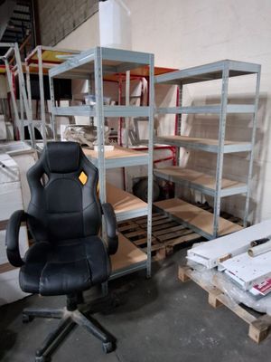une chaise de bureau noire posée devant une rangée d'étagères