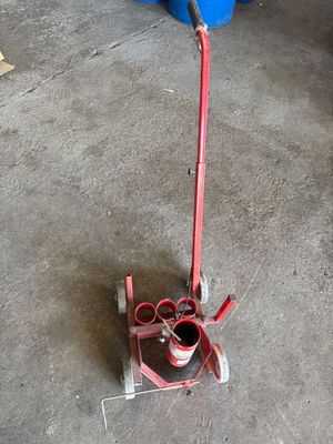 un diable rouge auquel est fixé un tuyau