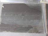a black piece of glass on the floor next to a black piece of glass