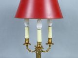 pair of brass table lamps with red lampshads and a red shade