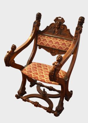 une chaise en bois dont l'assise est recouverte d'un tissu rouge et doré
