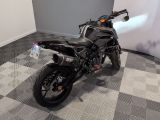 a black motorcycle parked in a room with a checkered floor