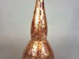 a gold and red vase sitting on a table