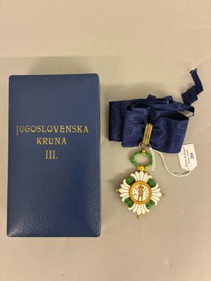 un livre bleu avec, à côté, une médaille d'or et un ruban bleu