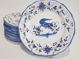 several blue and white plates with a bird on them on a table