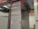 a picture of a room with a metal door and a sign on the wall
