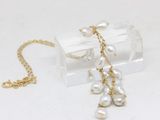 a necklace with pearls hanging from it on a clear box