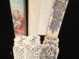 trois marque-pages en papier en forme d'éventail posés sur une table noire