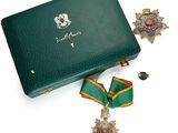 un écrin vert contenant une médaille d'or et un ruban vert