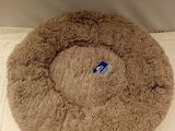a brown dog bed that is on a white surface