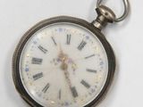 a close up of a pocket watch on a white surface