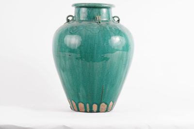 a large green vase sitting on a white table