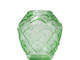 a green glass vase that is sitting on a white surface