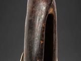 une photo d'une sculpture en bois représentant une personne dont la tête repose sur un socle
