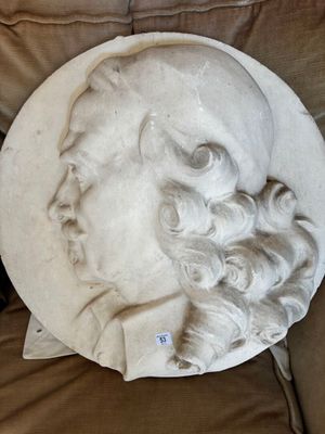 une statue représentant un homme barbu allongé sur un canapé