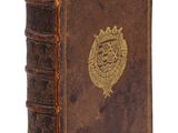 un vieux livre orné d'un emblème doré sur la couverture
