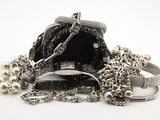 un sac à main noir entouré d'une chaîne, posé sur une surface blanche