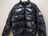 une veste noire accrochée au mur à côté d'un cintre