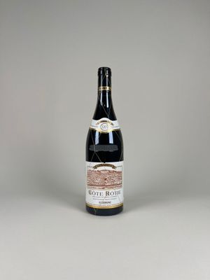 a bottle of wine sitting on top of a white table