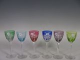 several different colored wine glasses are lined up in a row