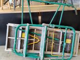 une photo d'un grand chariot vert auquel sont fixés des tuyaux