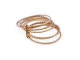 a close up of a stack of gold rings on a white background