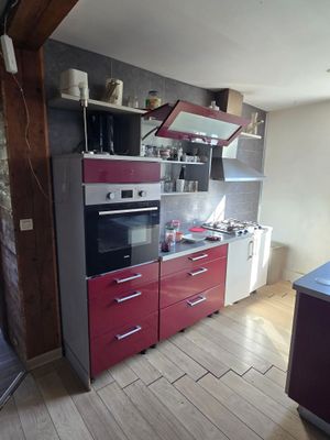 une image d'une cuisine avec une cuisinière et un réfrigérateur