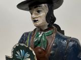 a figurine of a man with a hat holding a shield