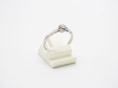 a close up of a diamond ring sitting on top of a white marble block
