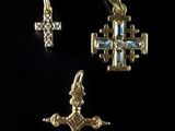 a close up of a cross and a cross pendant on a black background