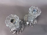 pair of clear glass candlestick holders on a gray background