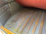 a truck bed with a mattress in the back of it