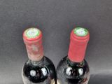 two bottles of wine sitting next to each other on a table