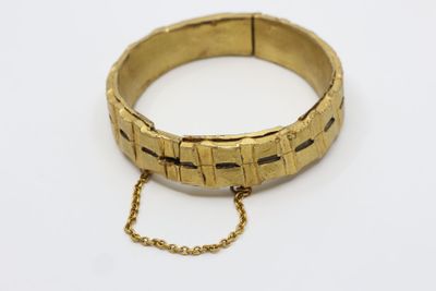 a close up of a gold bracelet with a chain around it